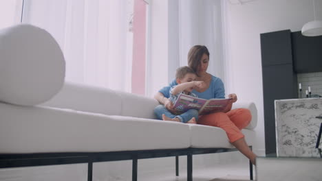madre sentada con su hijo leyendo una historia en el interior