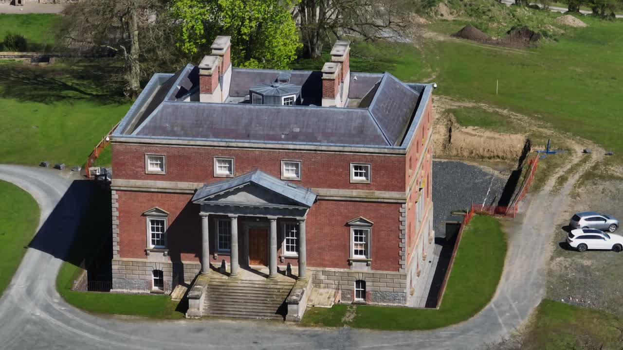 Bellamont House, County Cavan, Ireland, April 2023. Drone circling clockwise from front of Georgian architecture, spring greenery and elegant estate on sunny day.