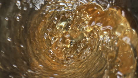 splashing hoppy drink bubbling goblet closeup. waving craft ale inside glass