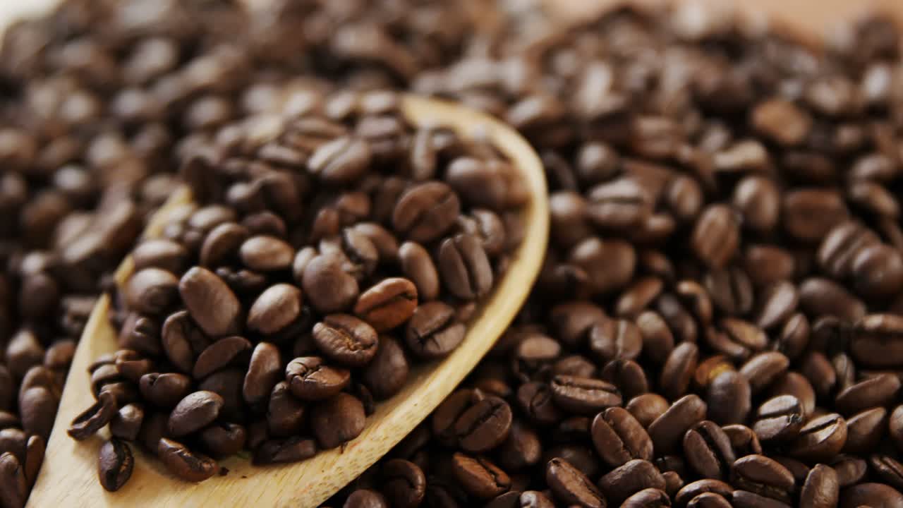 granos de café tostados con cuchara de madera