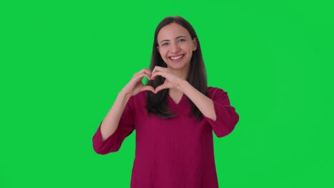 mujer india feliz mostrando el signo del corazón pantalla verde