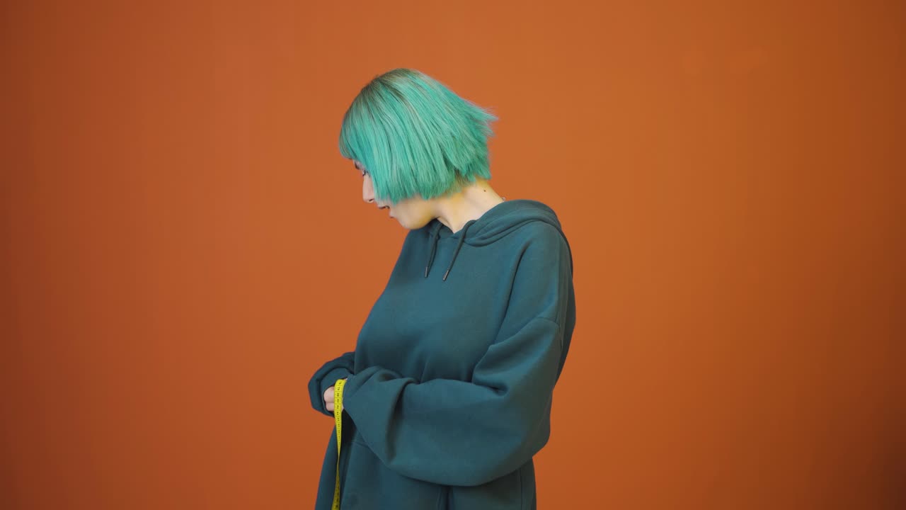 자신의 몸무게에 만족하는 젊은 여성.