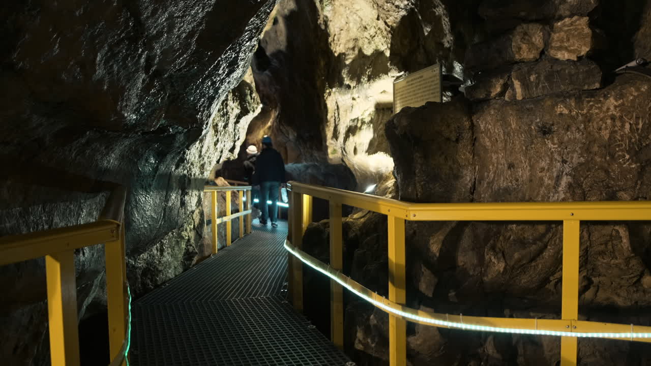 View of The Ialomitei Cave in Bucegi Mountains, Romania. Tourists, bridges, illumination