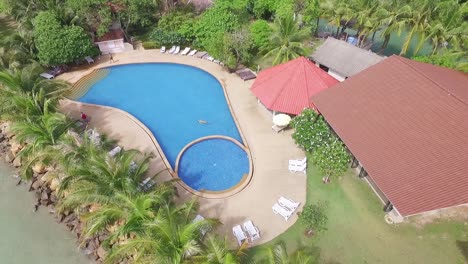 Aerail-tilt-down-top-view-above-luxury-Koh-Chang-Thailand-hotel-resort-and-colourful-pool