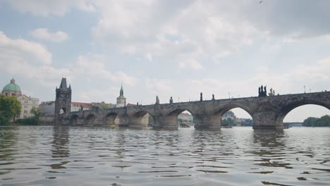 low angle establishing shot of charles bridge from vltava river prague