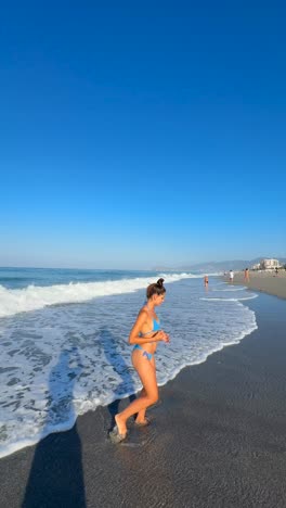 mujer en la playa con un bikini azul
