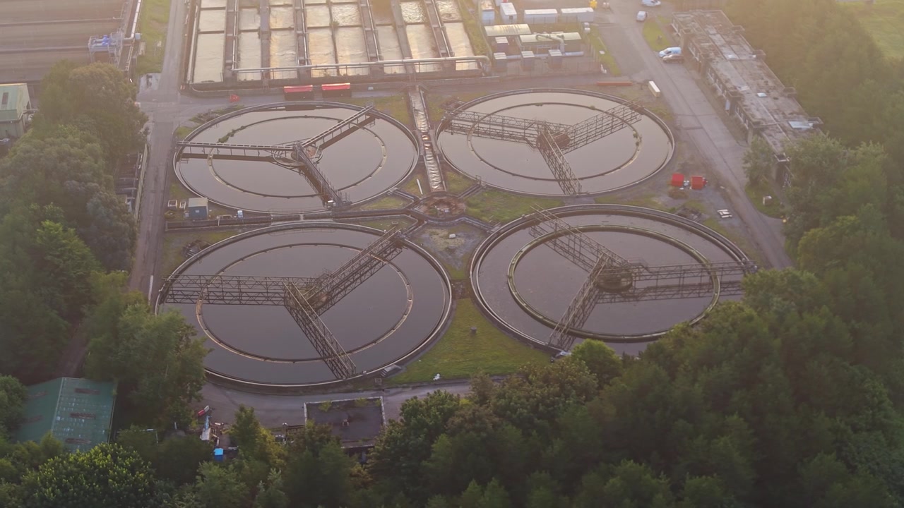 Close Aerial View of Water Treatment Plant and Wastewater Recycling Facility at sunrise. View of Secondary Clarifiers. Clean tech, sustainability, and environmental engineering concept.