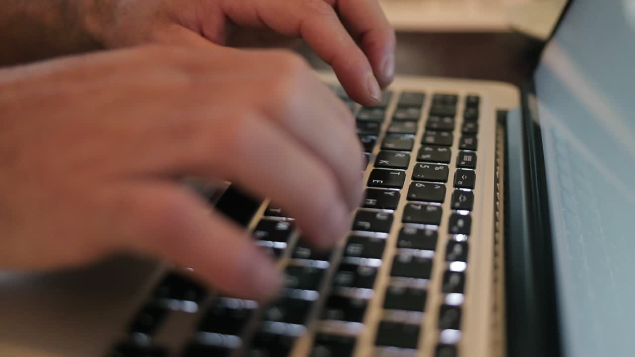 Male hands typing on laptop computer