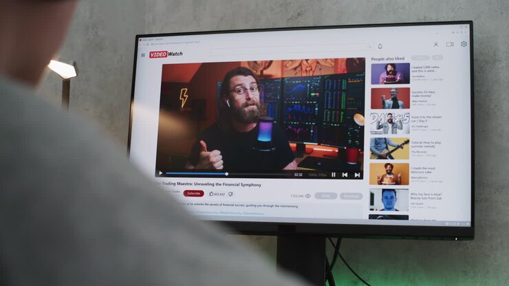 guardare un tutorial video di trading finanziario su un monitor computerizzato