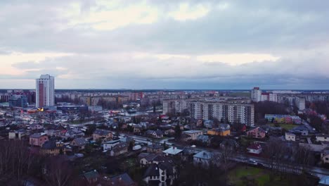 Aerial-drone-shot-of-Darzciems-district-residential-with-busy-road,-above-trees