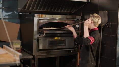 chef horneando pizza en la cocina de un restaurante