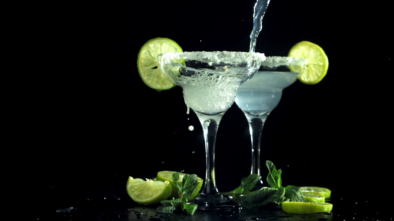 Hælder Margarita cocktail i et glas med saltkant og limepynt