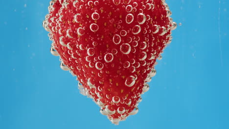 strawberry submerged in water with bubbles