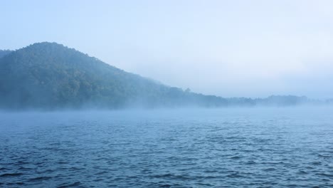 misty river with mountain in the background