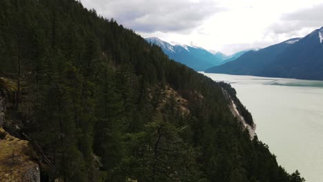 drone shot flying over trees at lillooet lake in british columbia, canada