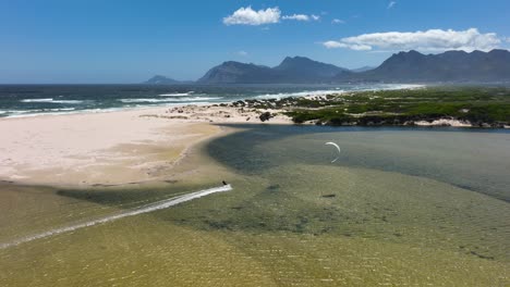 Kitesurfen-In-Der-Nähe-Der-Sandküste-Südafrikas-Mit-Bergkette-Am-Horizont