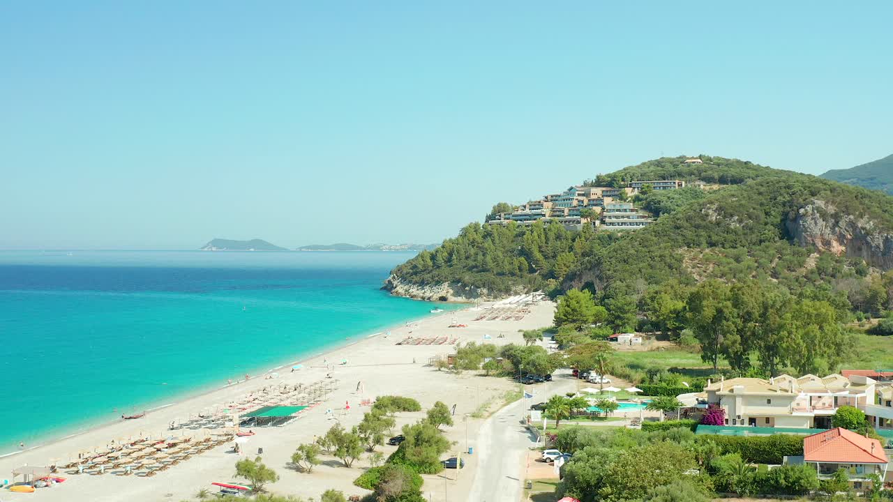 Aerial dolly shot over Karavostasi Beach scenery, Turquoise water and Luxury resort, Greece