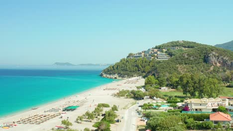 aerial dolly shot over karavostasi beach scenery, turquoise water and luxury resort, greece