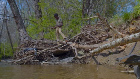 Adult-black-man-leisurely-playing-ricochet-near-creek-in-Kentucky-during-spring