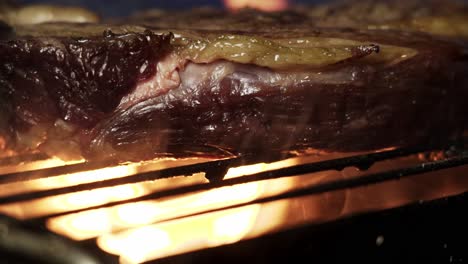spinning meat amidst flames on barbecue