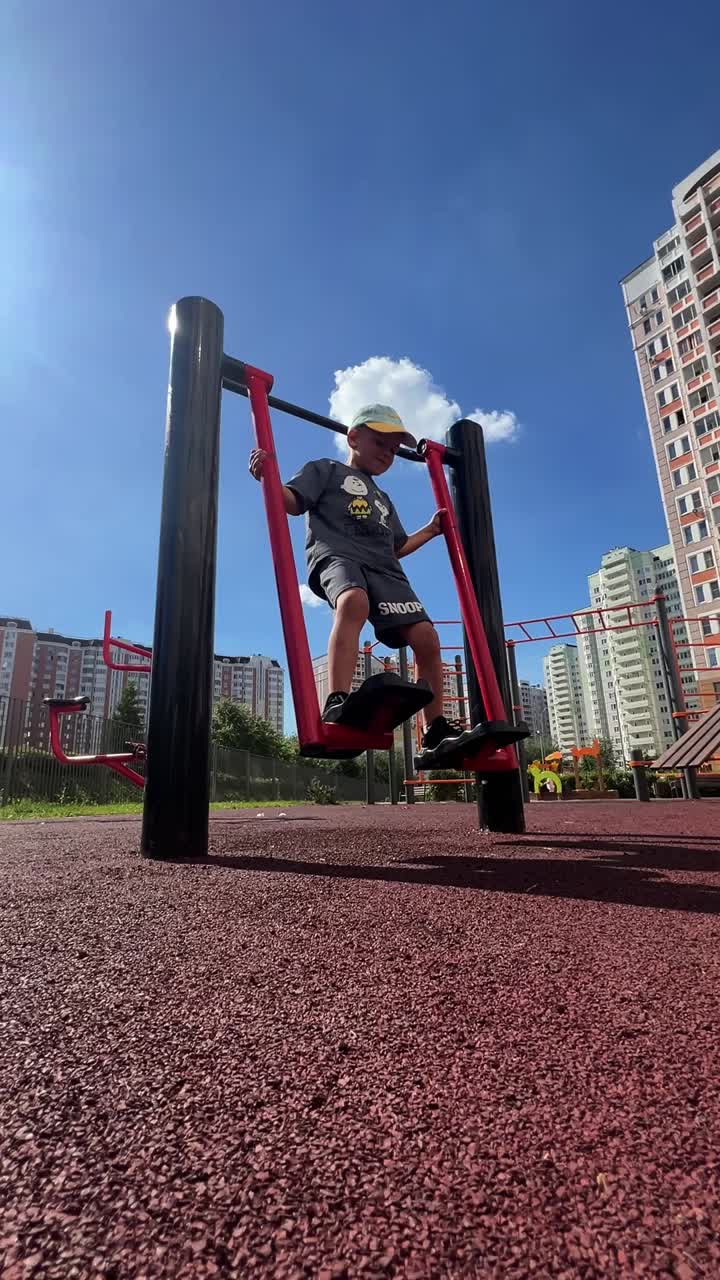 Boy playing on exercise machine in outdoor playground