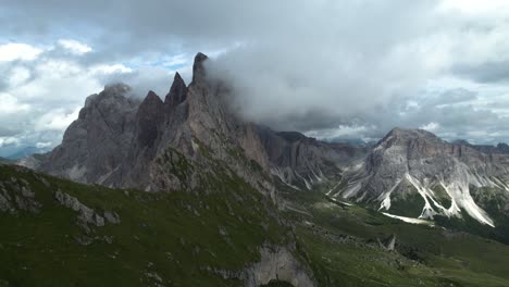 seceda mountains in the italian dolomites with the clouds covering the steep pinnacle shaped cliffs