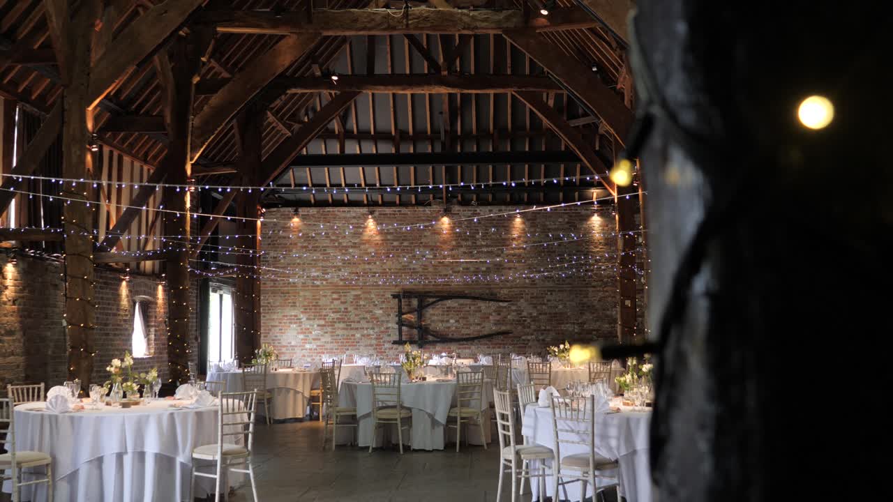 Vertical slider shot revealing wedding setup in an enchanting barn venue