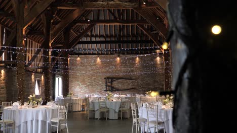 Vertical-slider-shot-revealing-wedding-setup-in-an-enchanting-barn-venue