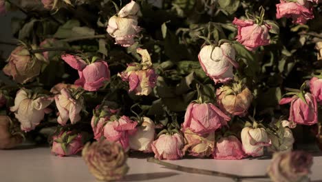 bouquet of withered pink rose flowers. dried roses on a table in dark room