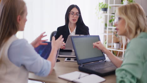 dos asistentes discuten los resultados de ventas con el jefe
