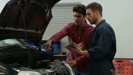 mecánicos que revisan un motor