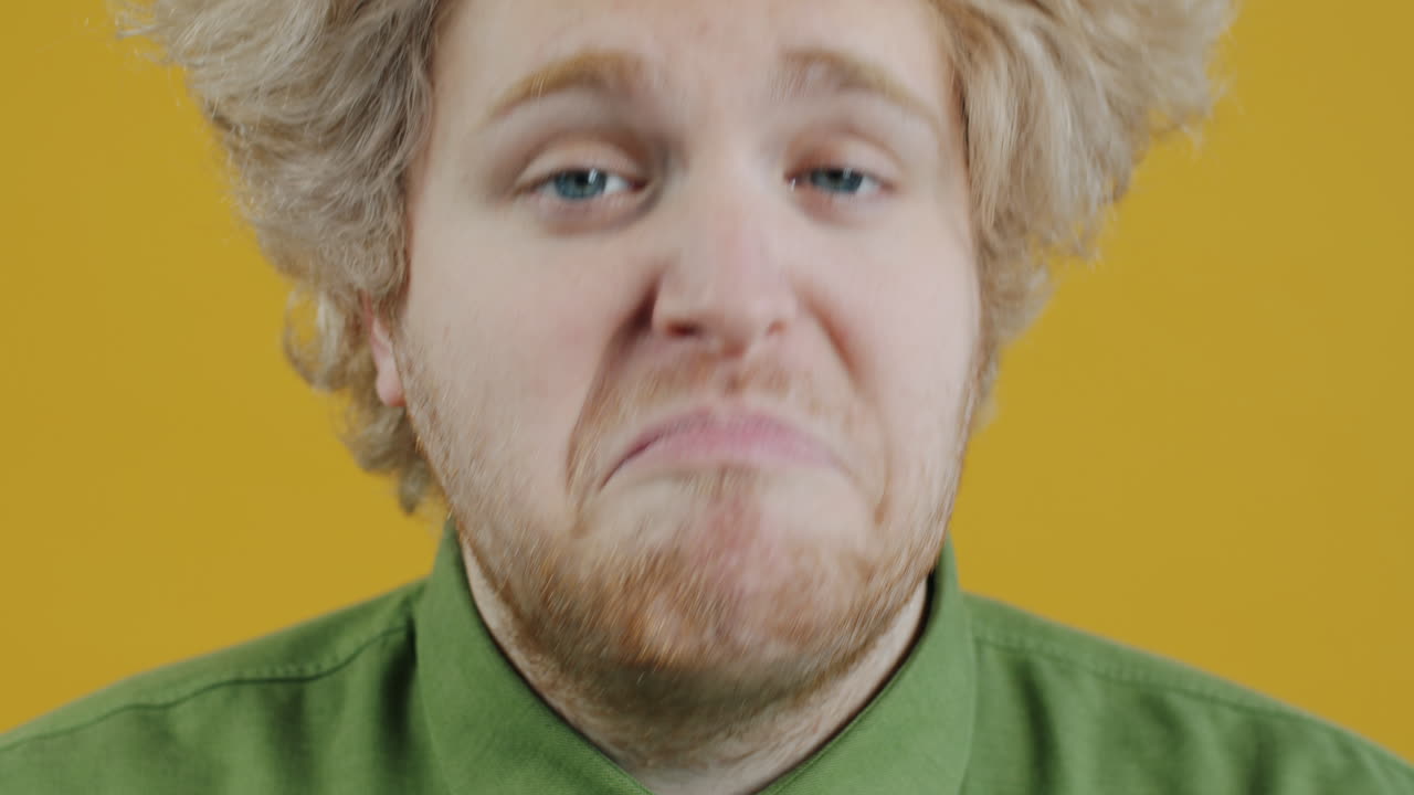 Close-up portrait of a man with an expression of concern or disappointment.