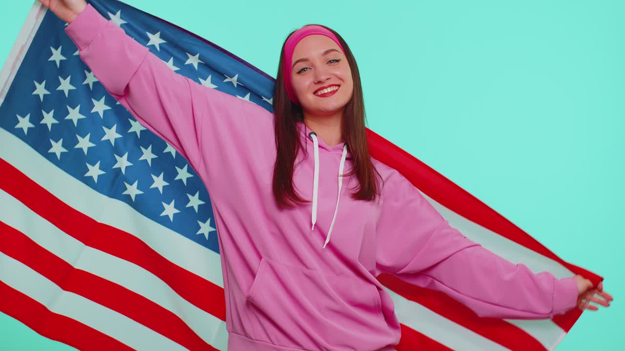 Cheerful teen girl waving and wrapping in american usa flag celebrating human rights and freedoms