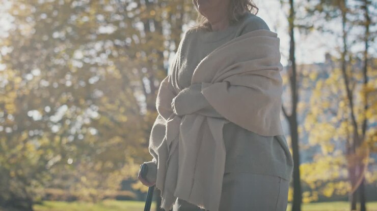 Senior woman with walking stick at the park