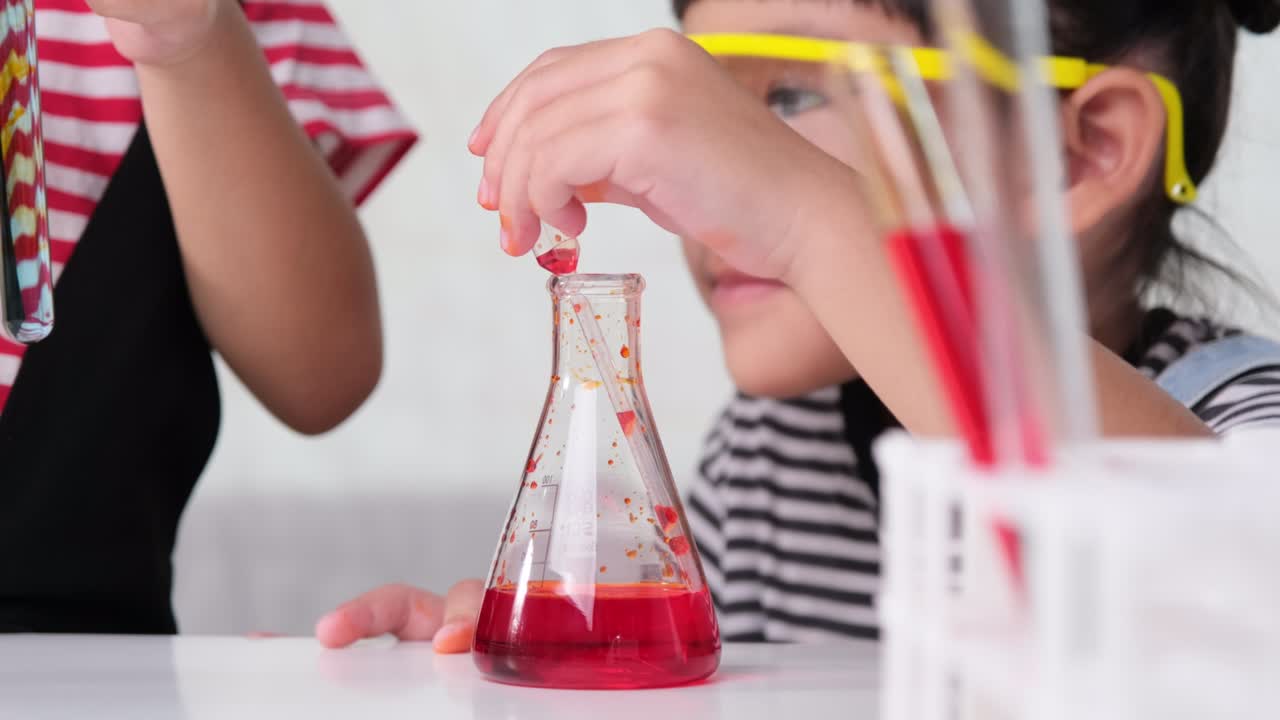 los niños están aprendiendo y haciendo experimentos científicos en el aula. dos hermanas pequeñas jugando a experimentos científicos para la escuela en casa. experimentos científicos fáciles y divertidos para los niños en casa.