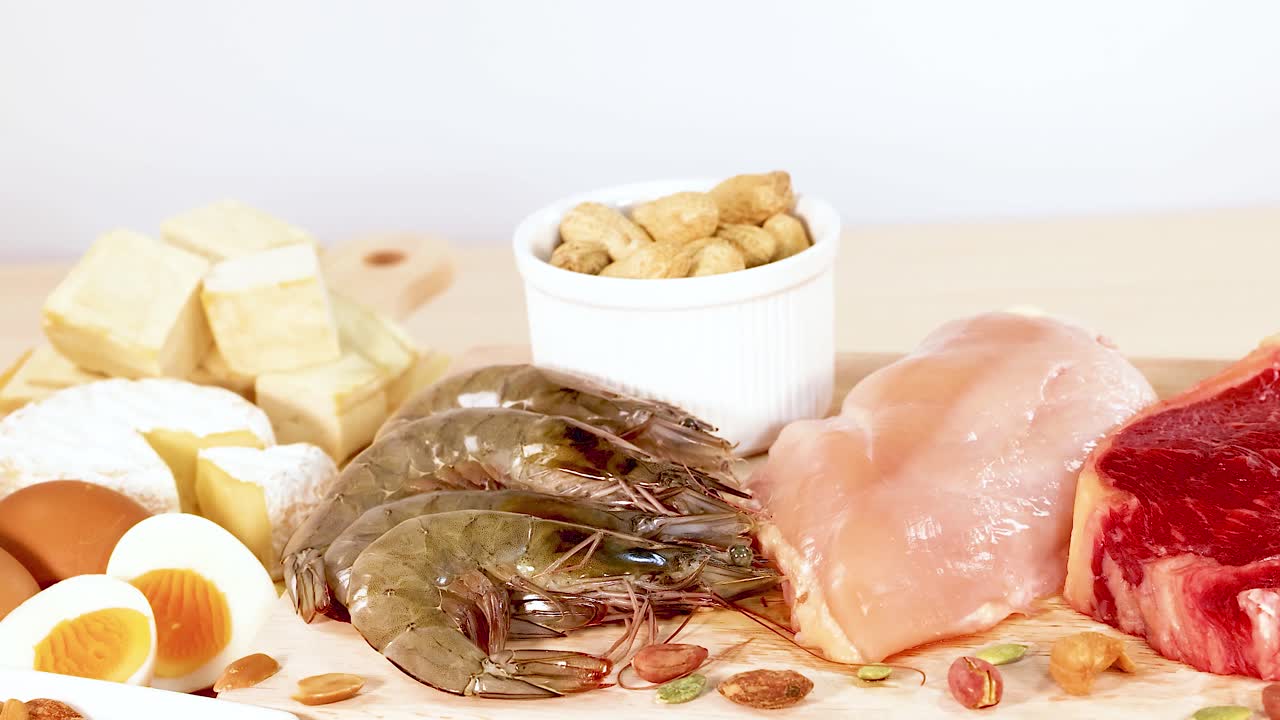 견과류, 해산물, 고기, 유제품을 포함한 다양한 단백질이 풍부한 음식의 활기찬 디스플레이, 밝은 조명으로 포착