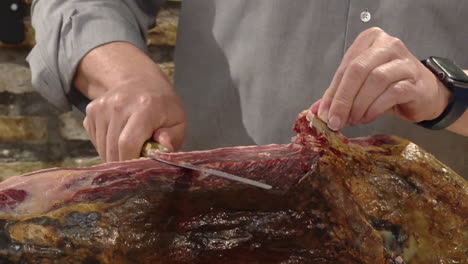 cutting a piece of jamón