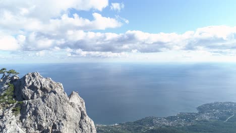 mountainous cliffside view of ocean and clouds