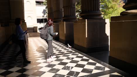 pedestrians walking near state library victoria entrance