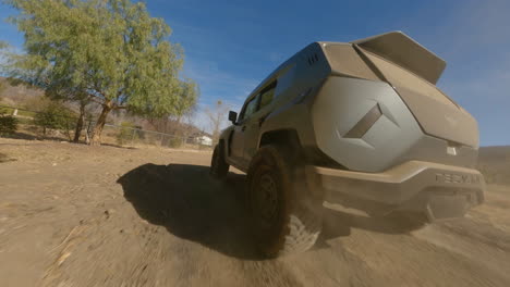 Fpv-drone-shot-of-black-car-driving-fast-on-dusty-road