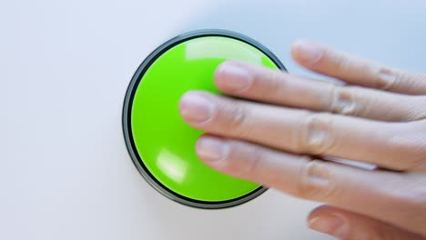 young woman pushing green button with a finger and palm of her hand. press a round glossy button, top view. activation, launching something. turn on and off.