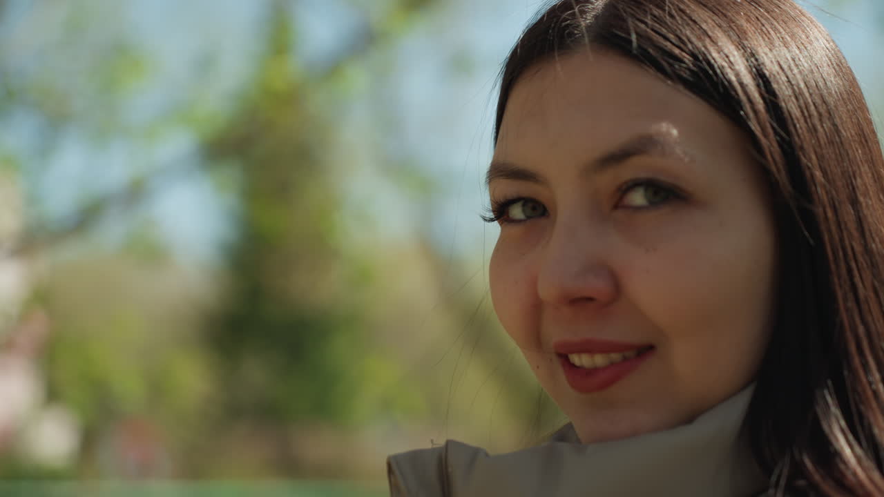 햇빛이 비치는 야외의 초록빛과 햇살 아래에서 자연의 향기를 담아내는 여성 참가자, 밝은 햇빛 아래 야외 라이프스타일 사진 촬영 중 생기 넘치는 노란 꽃과 교감하는 여성