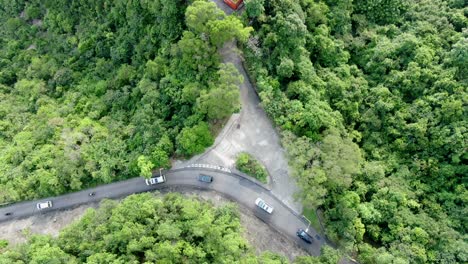 vista aérea de una estrecha y sinuosa carretera de montaña rodeada de una exuberante naturaleza verde