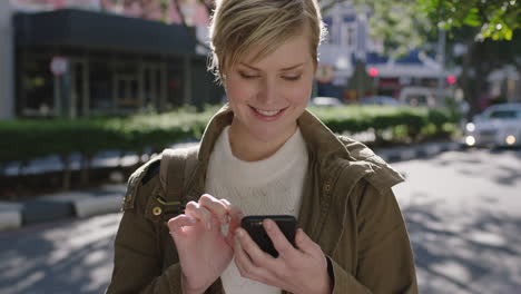 portrait of beautiful blonde woman standing on sidewalk texting browsing using smartphone enjoying travel