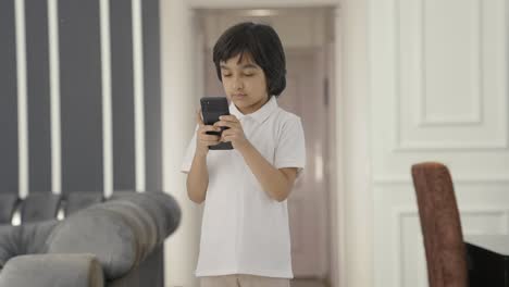 Niño-Indio-Enviando-Mensajes-De-Texto-A-Alguien-Por-Teléfono