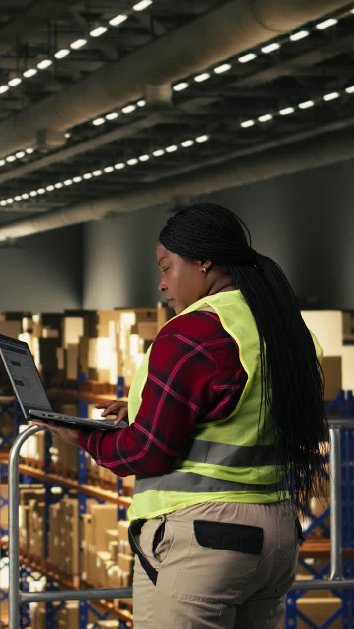 Video verticale: lavoratore afroamericano che gestisce spedizioni e consegne utilizzando un laptop