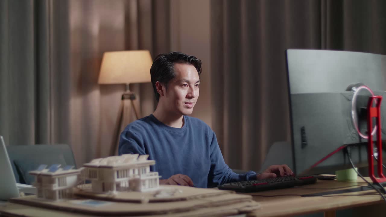 건축 모델 을 가진 컴퓨터 에서 집 에서 일 하는 사람