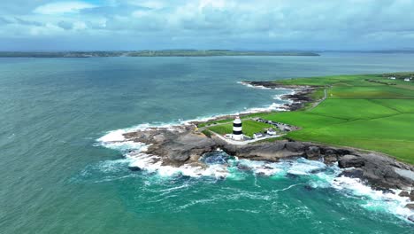 Irland-Epische-Orte-Hook-Head-Leuchtturm-Wexford-Drohne-Umkreist-Die-Landzunge-Und-Enthüllt-Die-Küste-Von-Waterford-Im-Hintergrund-An-Einem-Atemberaubenden-Tag-Im-Sommer