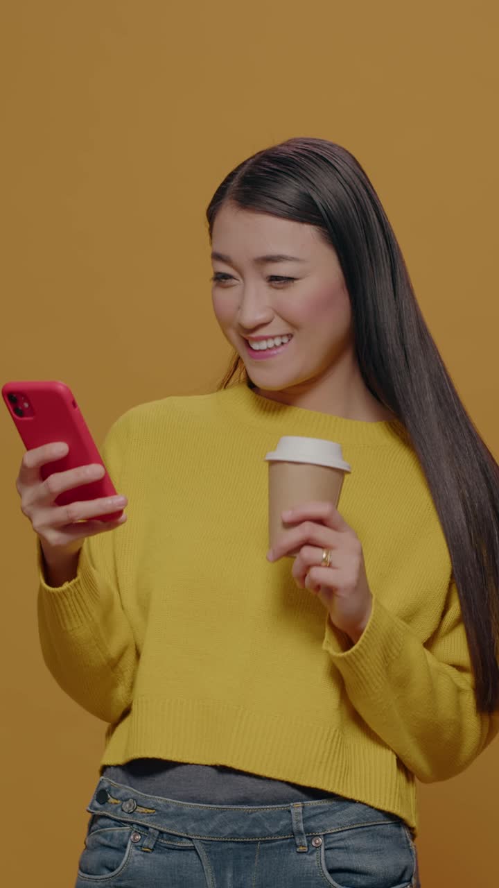 Donna che usa il telefono e tiene in mano un caffè