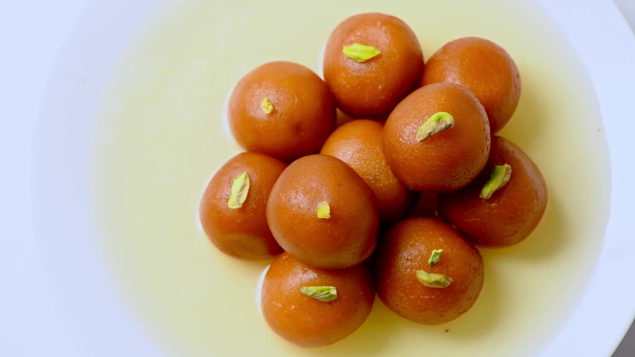 gulab jamun girando con pistacho encima ( dulce indio ) | postre | primer tiro de gulab jamuns
